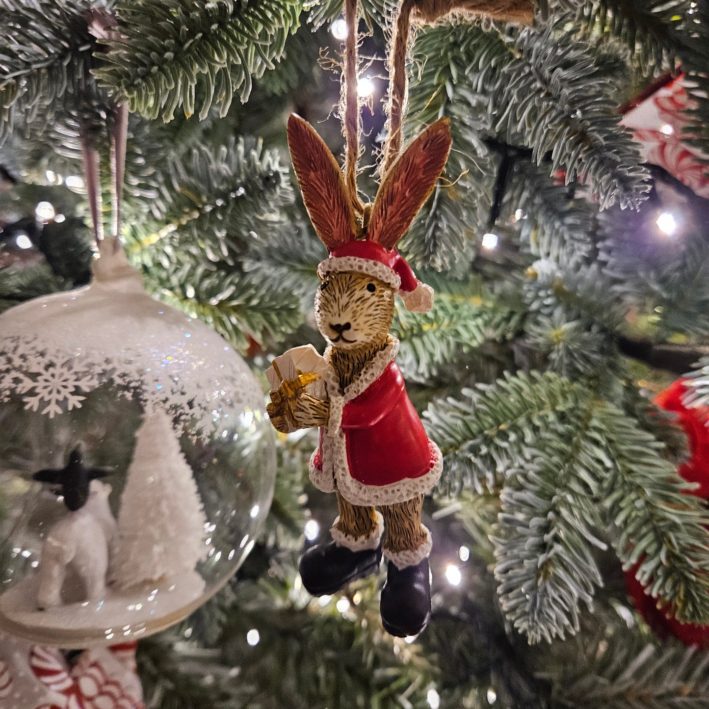 hanging bunny dressed as santa with a present tree decoration
