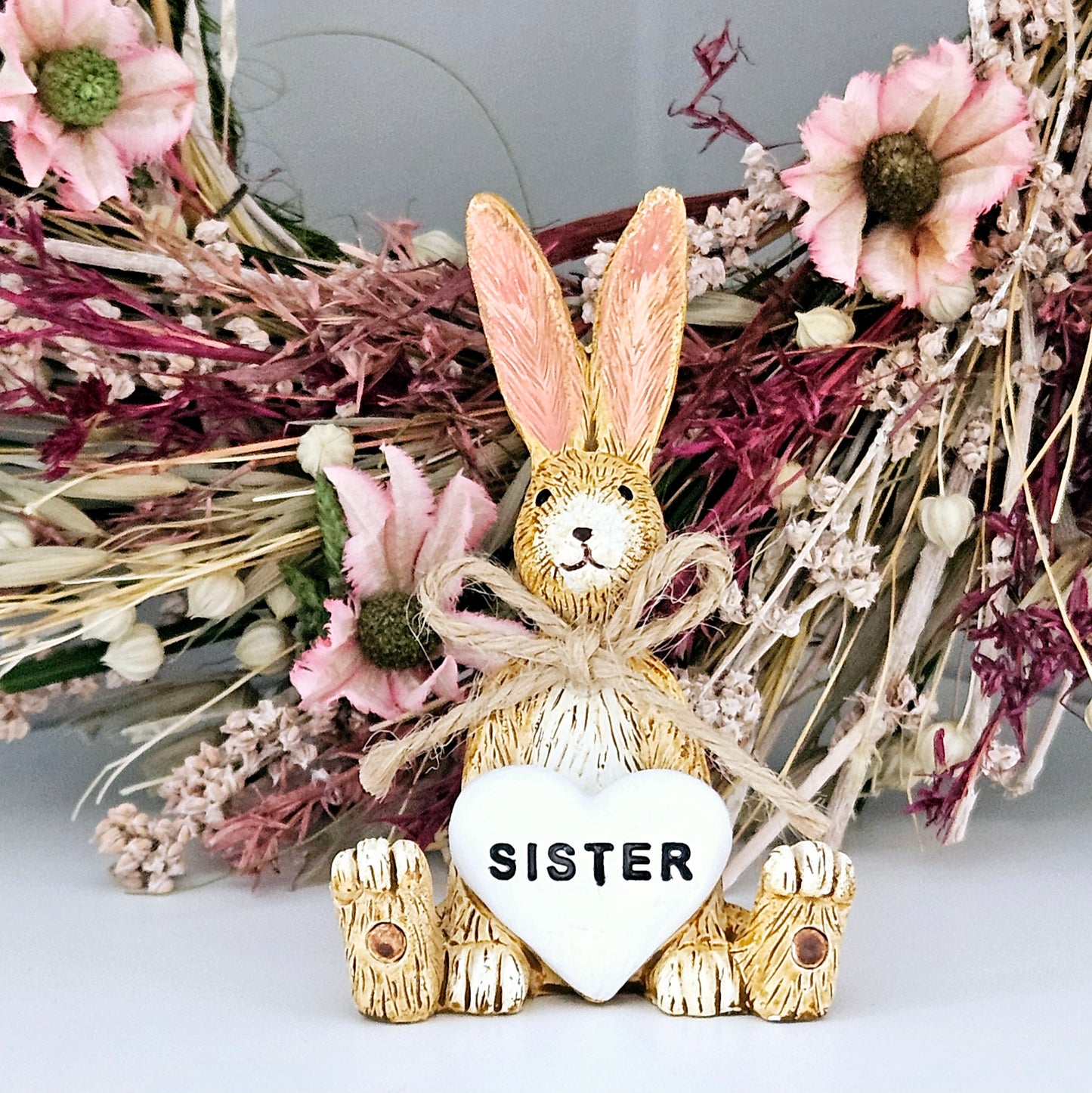 Sitting cute rabbit with white heart saying sister