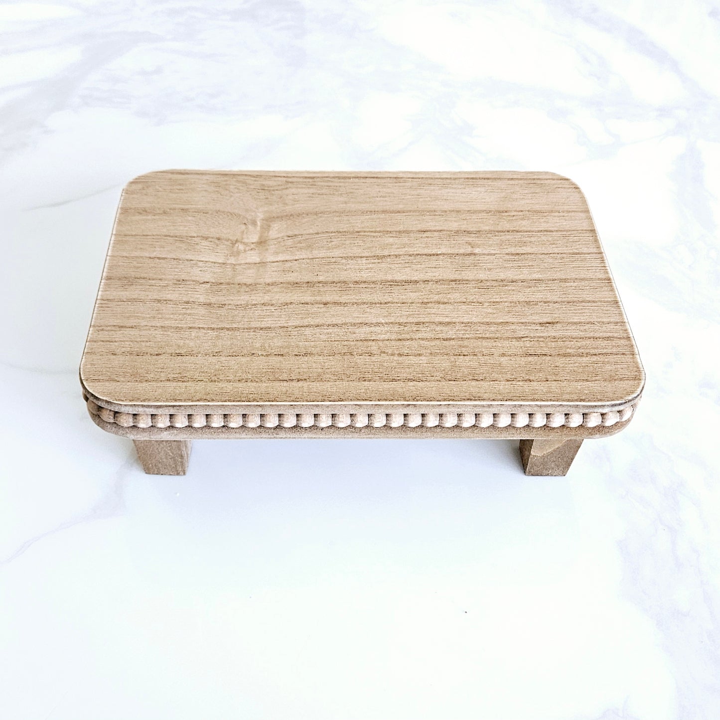 Natural wood beaded riser tray for styling