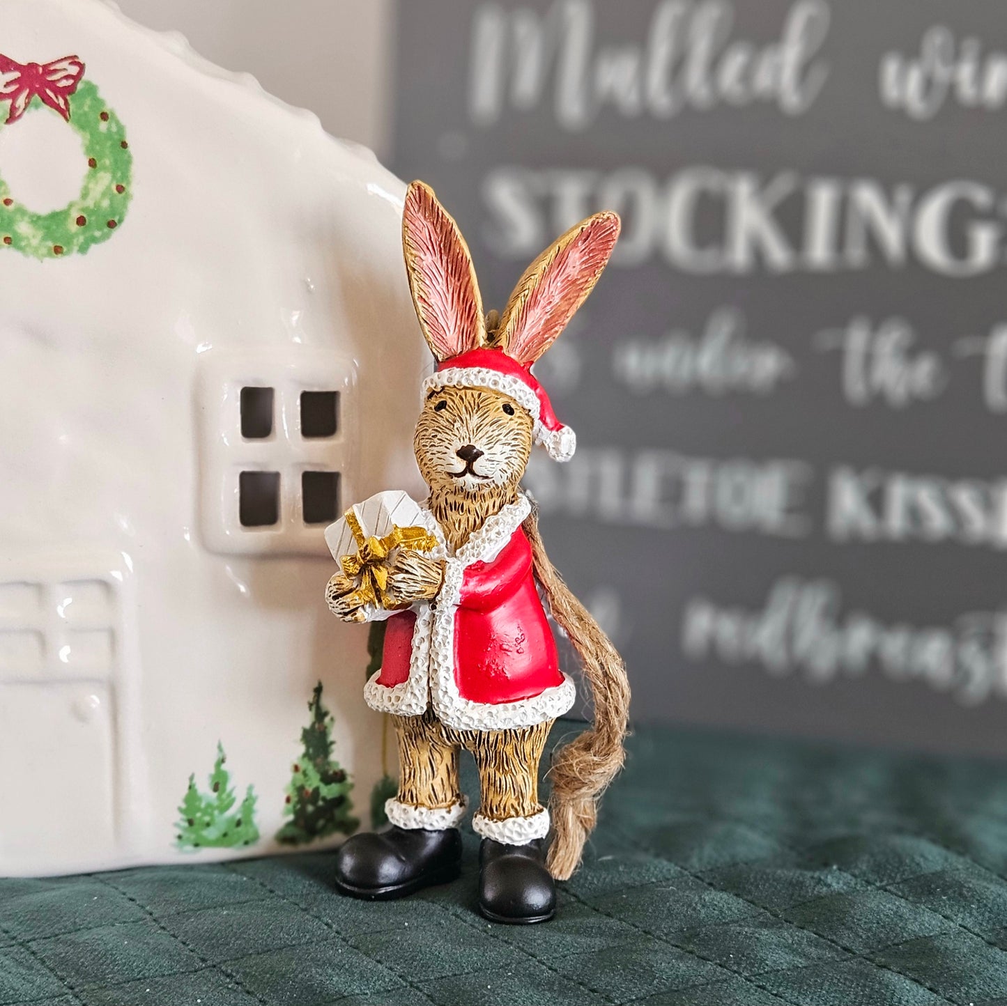 santa bunny ornament which hangs y a brown jute rope holding a present
