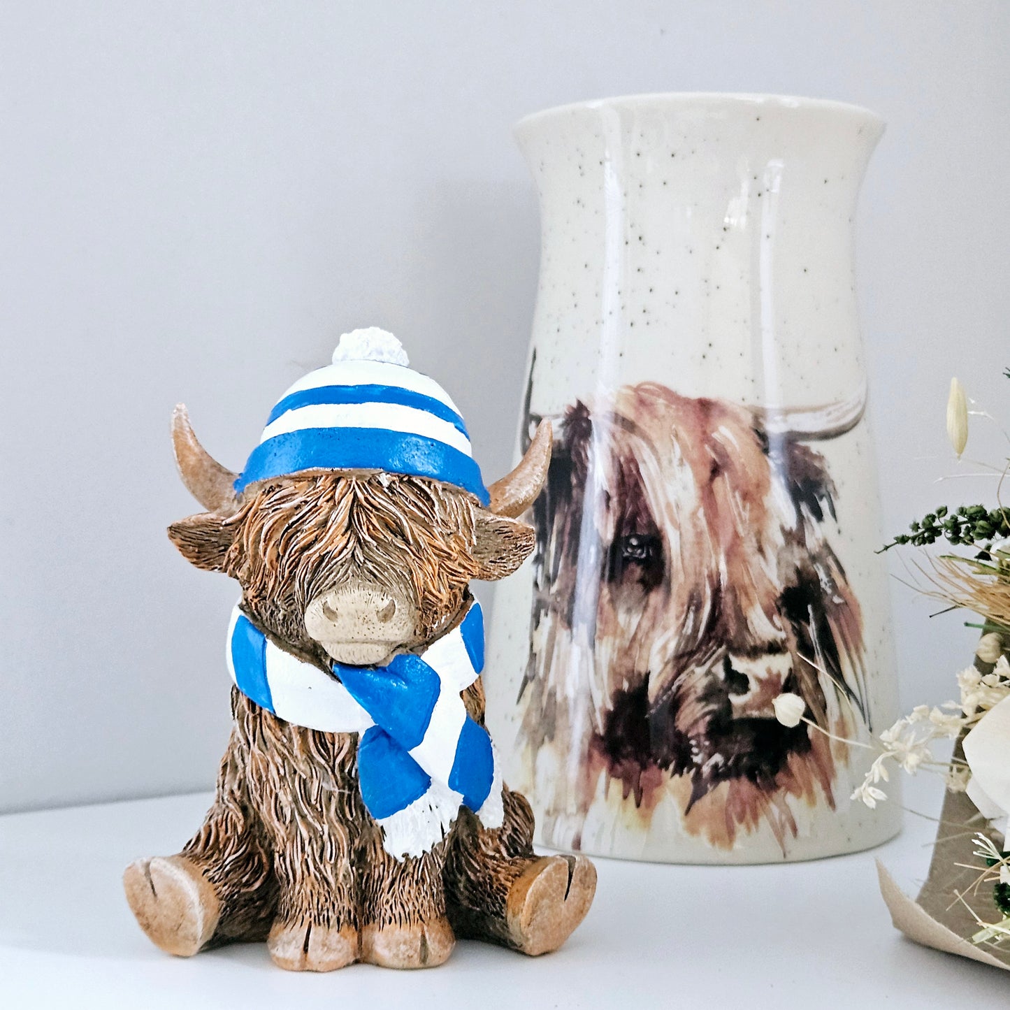 Highland cow Ornament wearing a blue and white stripped hat and scarf