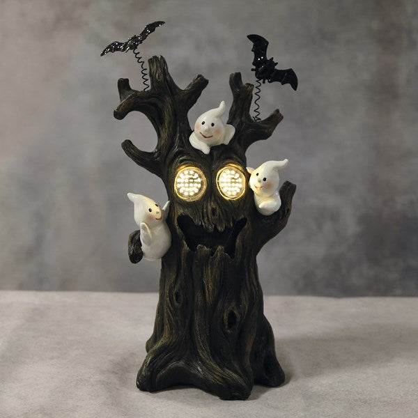 A Halloween-themed decorative tree stump figurine with glowing round eyes, three small white ghost figures, and two black bats perched on the branches. lED ghost scary tree Halloween decoration