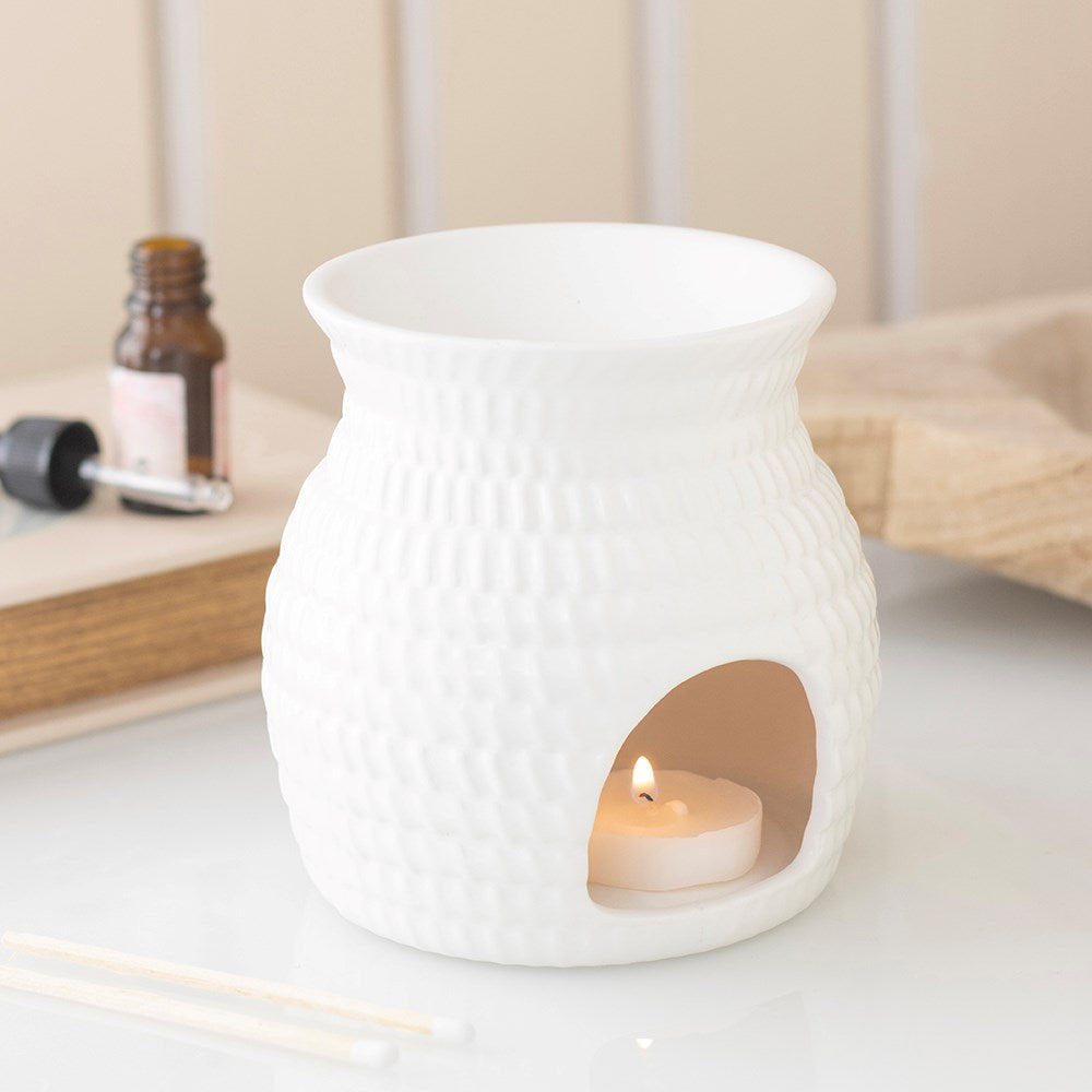 White ceramic oil burner and wax warmer in a woven basket white detail
