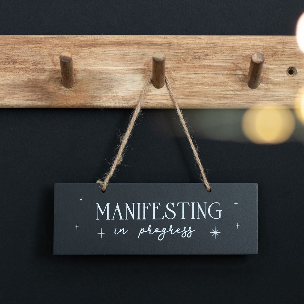 manifesting hanging black sign in progress