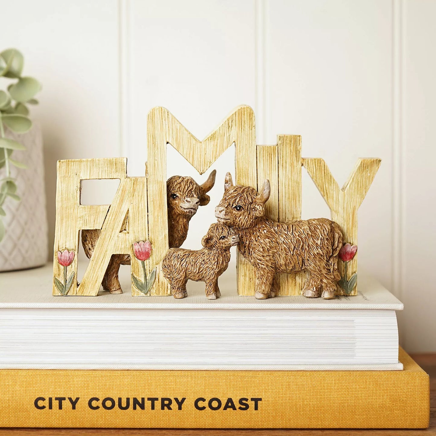 Decorative wooden letters spelling 'FAMILY' with 3 highland cows and tulips