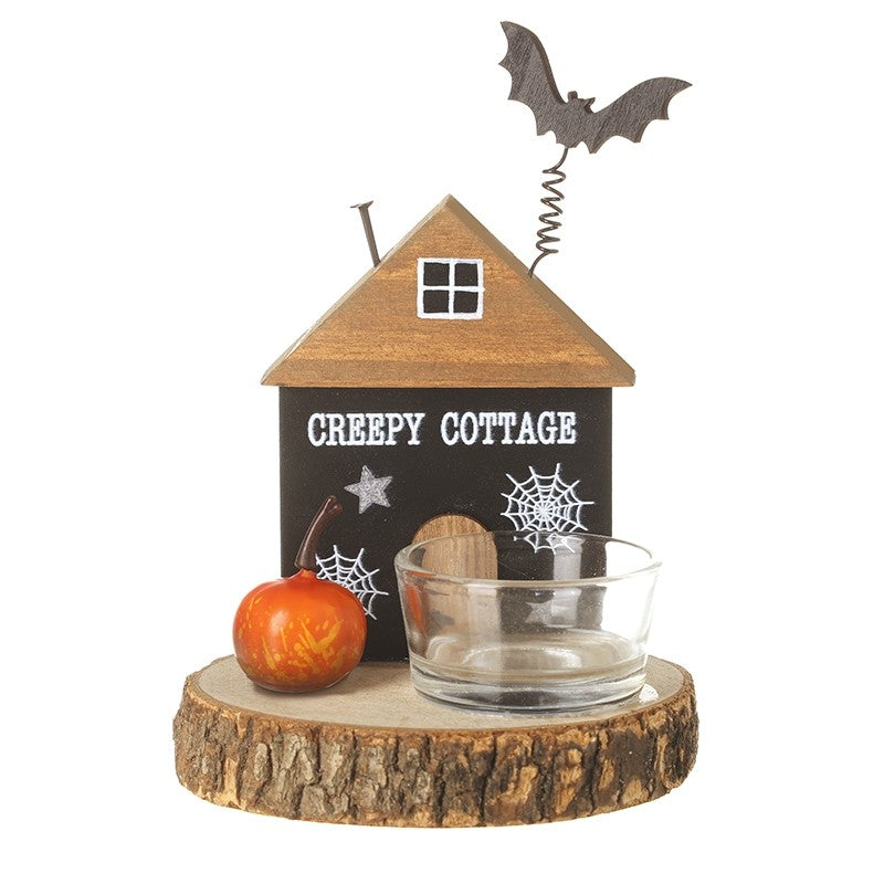 Halloween-themed decorative item with a 'Creepy Cottage' wooden house, small pumpkin, and glass teal light bowl and bat on roof