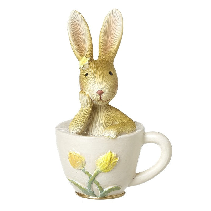 Decorative rabbit figurine inside a teacup with tulips