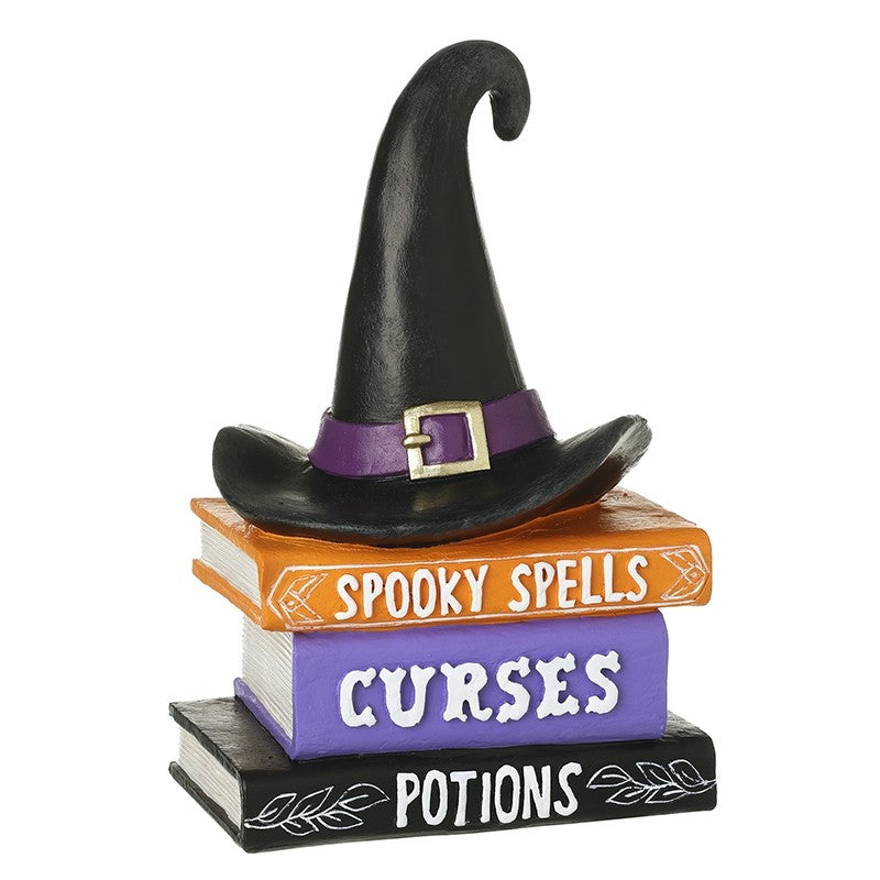Decorative witch hat on top of 3 books spooky spells curses and potions