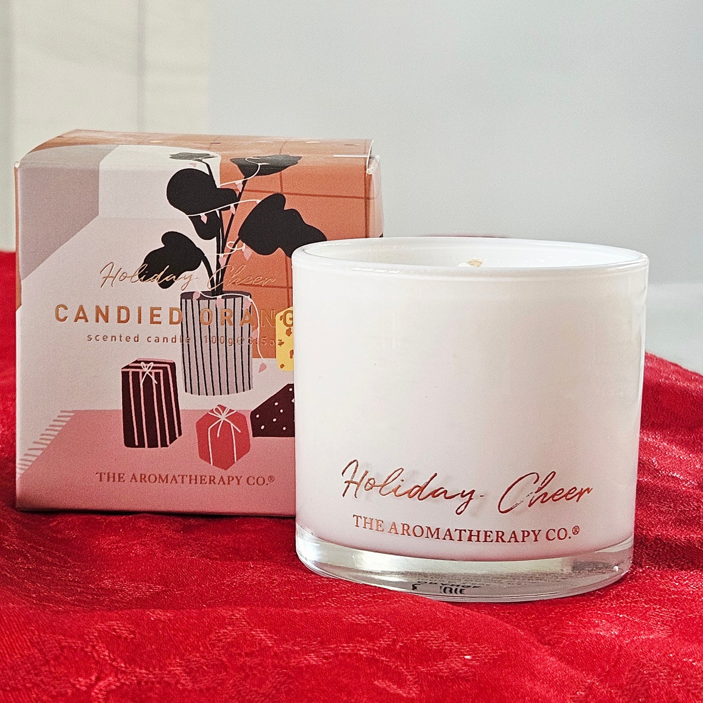 Candle labeled 'Holiday Cheer' from The Aromatherapy Co. with packaging