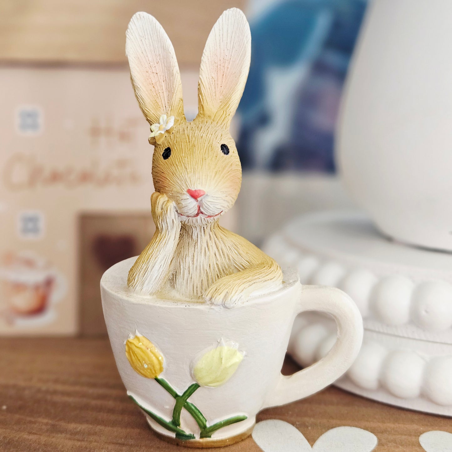 Decorative rabbit figurine in a teacup with tulips