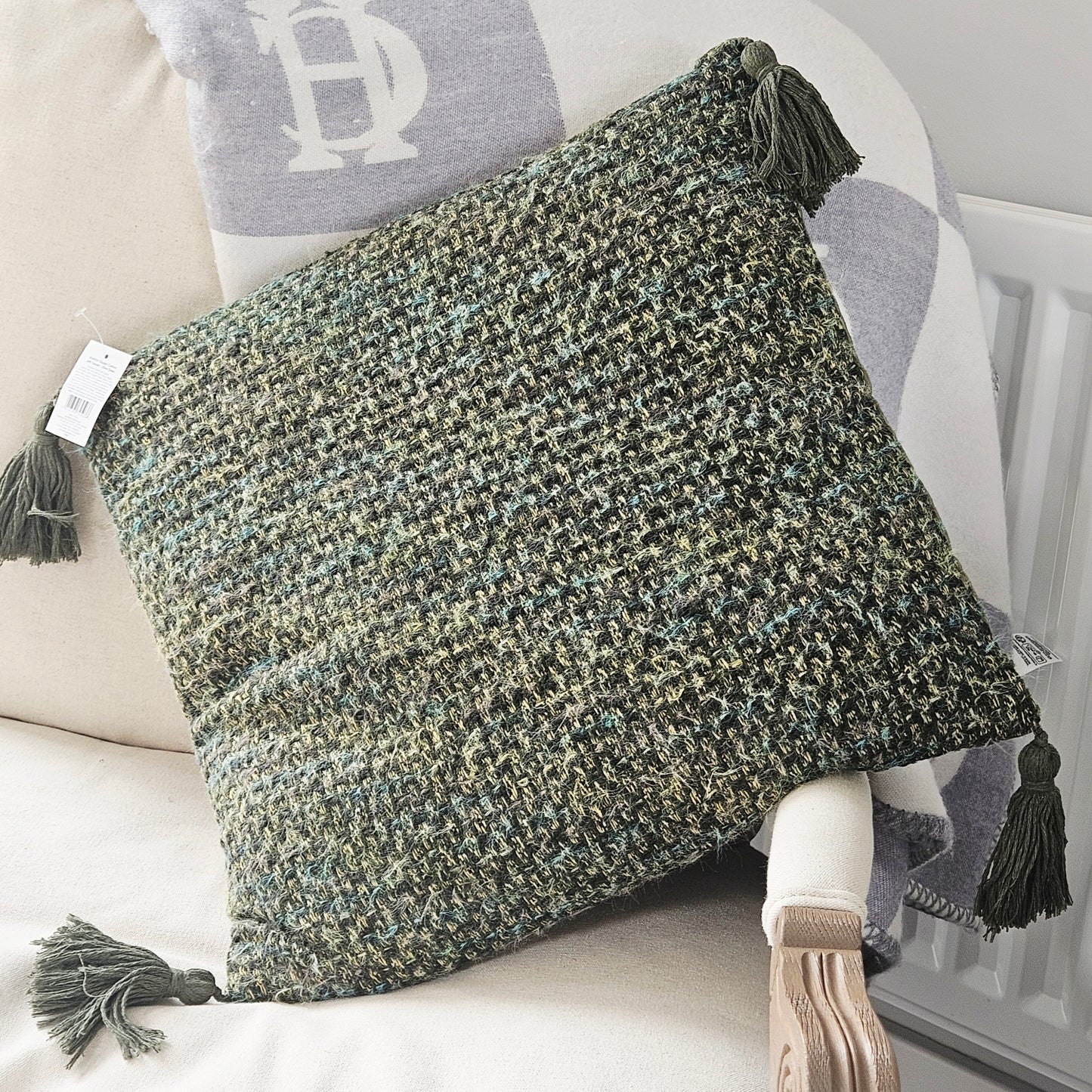 Textured woven green square cushion with tassels