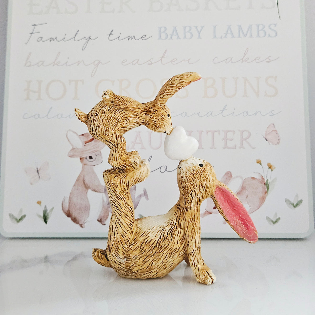 Jasper and Bonnie resin rabbit ornament sharing a kiss with a heart between them
