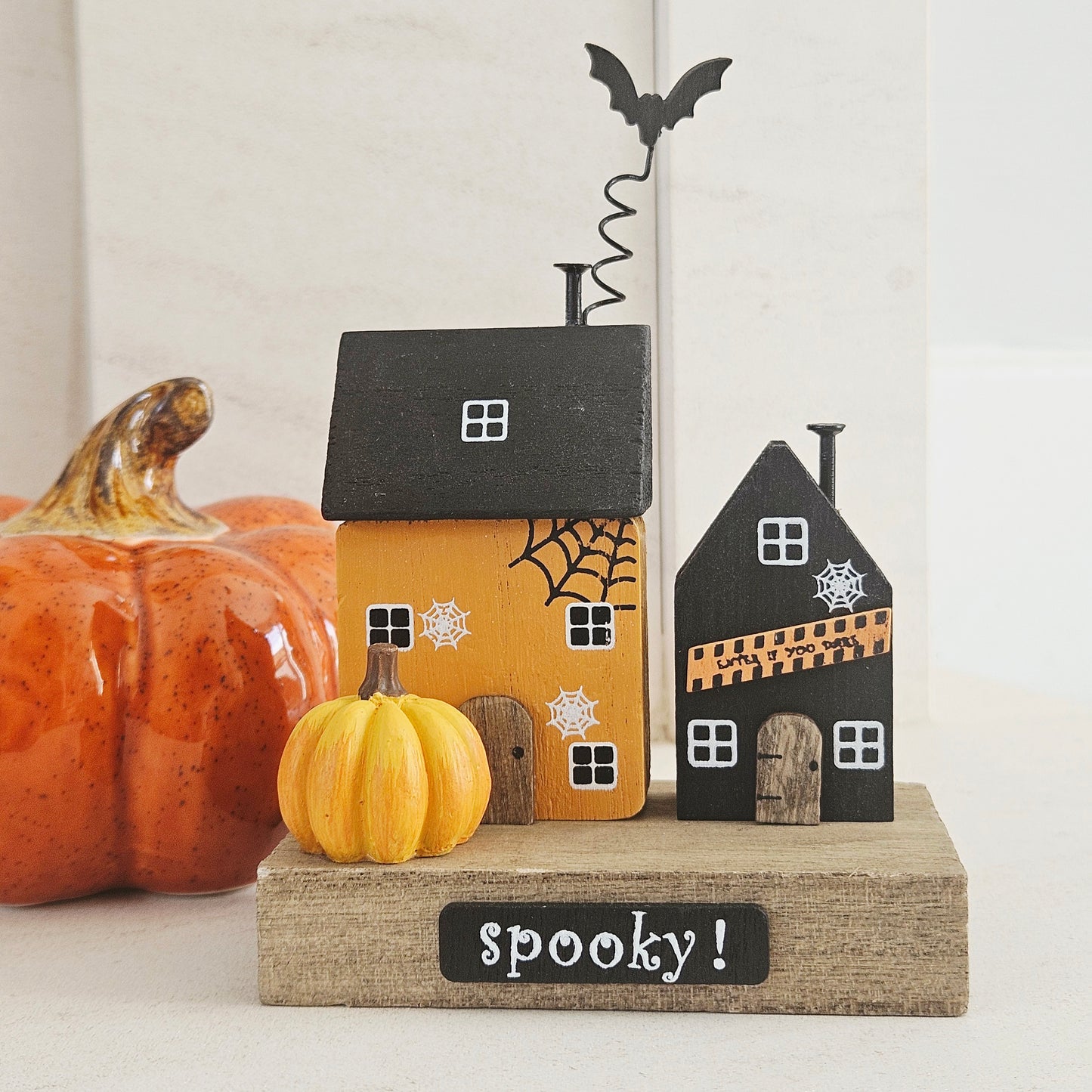 Halloween-themed wooden decorative house set with pumpkins and a bat