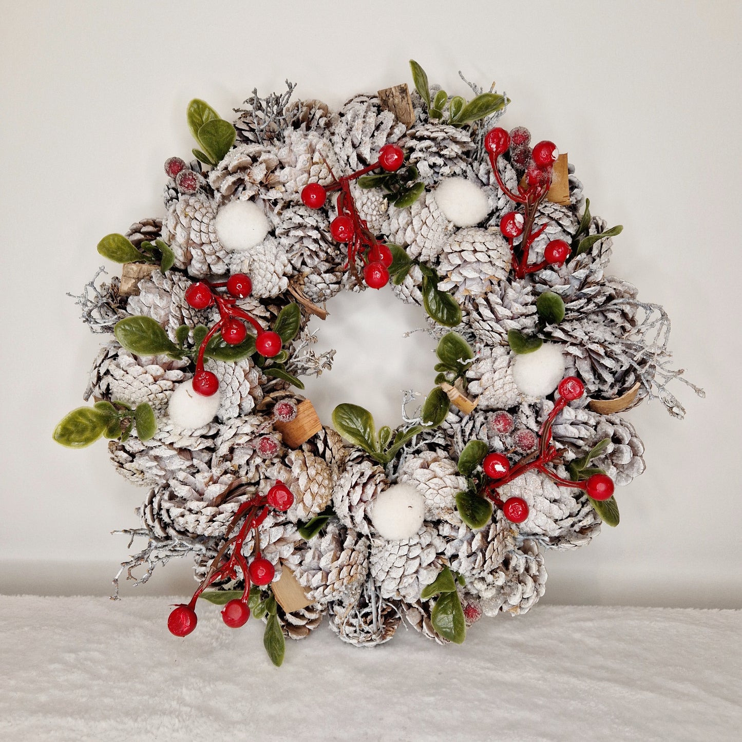 White & Red Pinecone Wreath made with a Mixture of Faux and Natural Materials, and String Hanger.