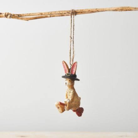Flying witch rabbit on a broomstick with a black hat and rope