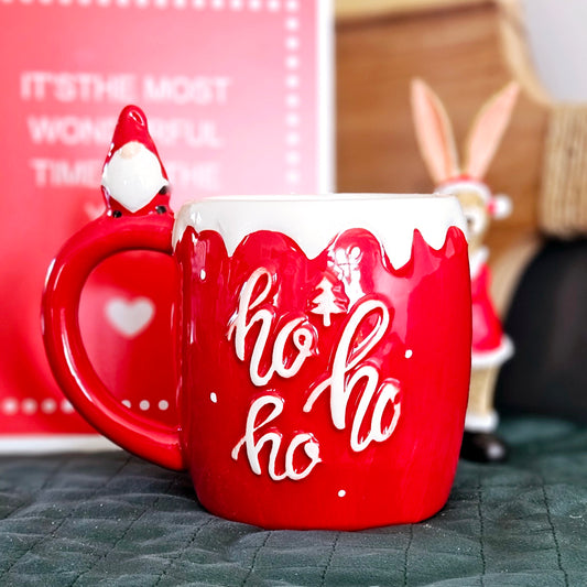 Red and white gonk/gnome mug with gonk figurine sitting on the handle and ho ho ho wording 