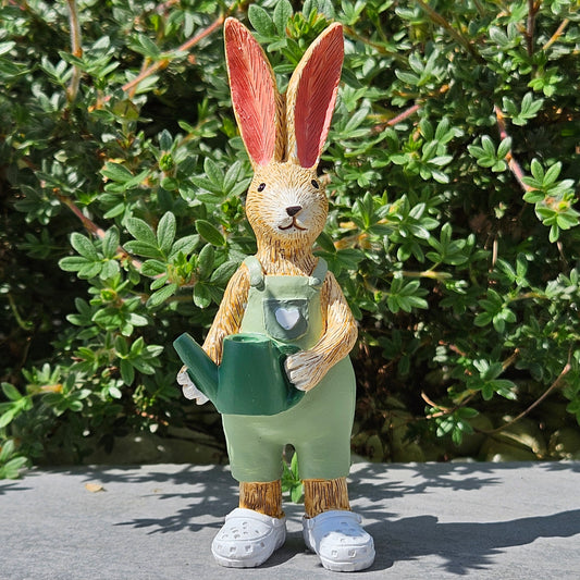 garden bunny figurine holding a watering can wearing white crocs