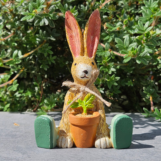 sitting garden bunny figurine holding a plant pot with jute bow