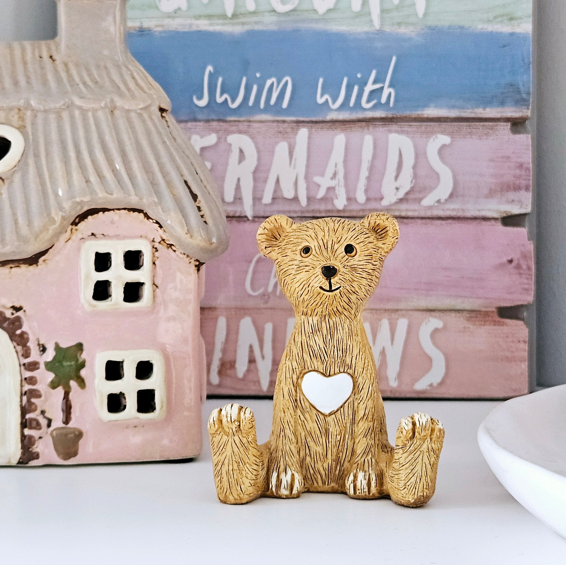 sitting bear figurine with white heart on tummy