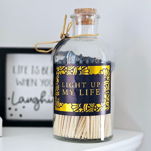 matches in a glass jar with navy blue tips cork top and light up my life print