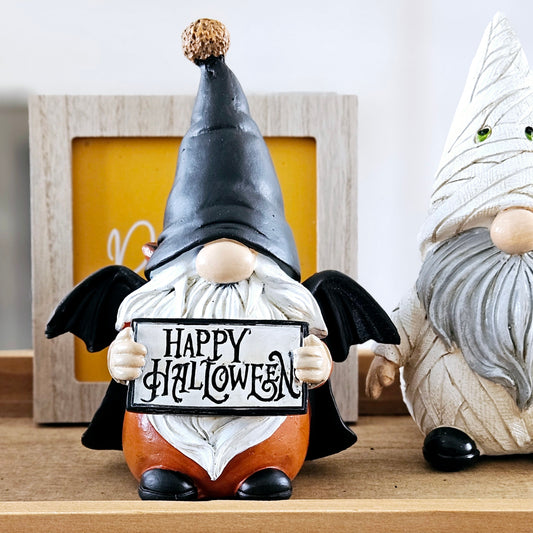 gnome ornament holding a happy halloween sign dressed as a vampire