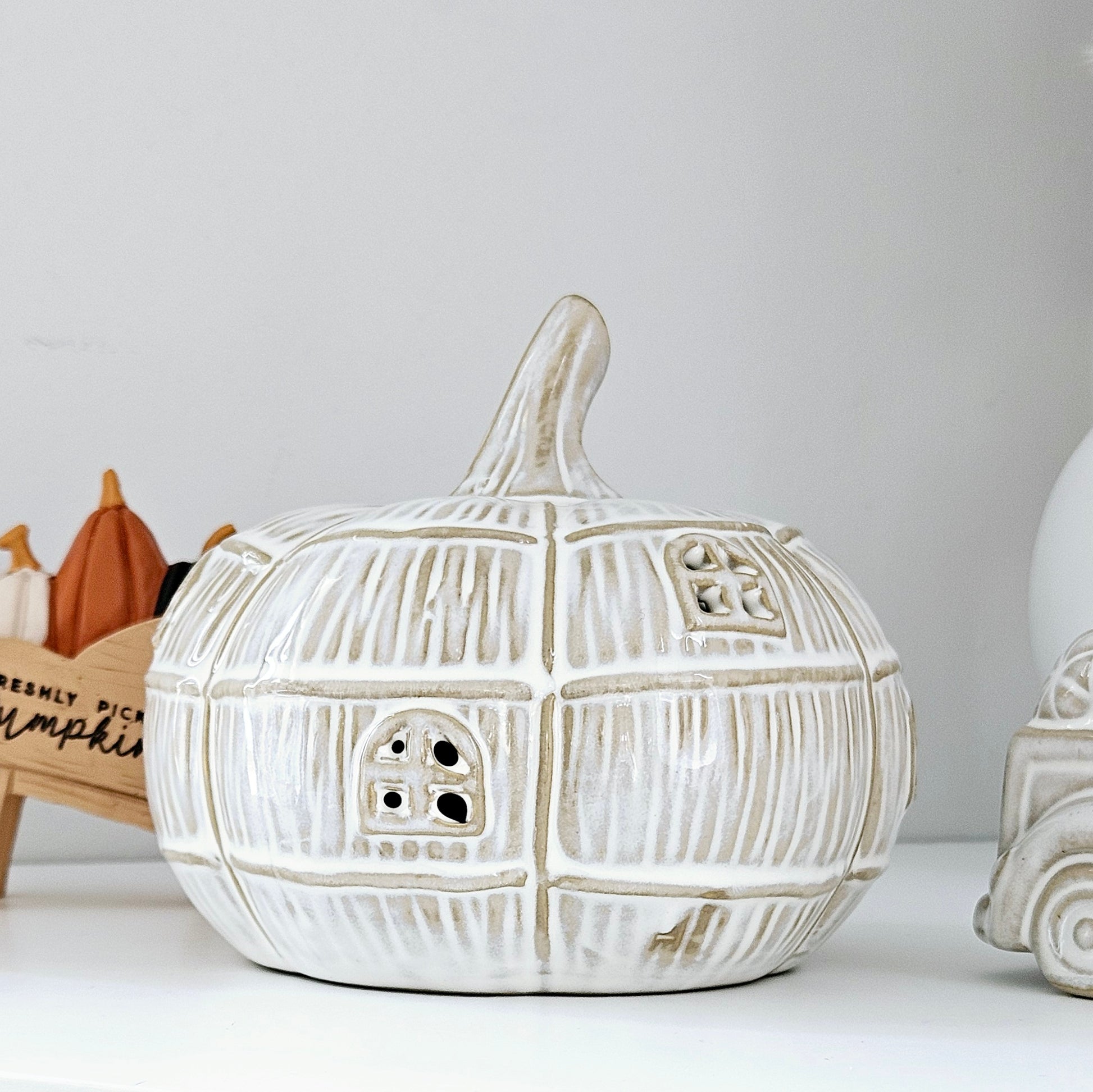 led pumpkin shaped ceramic house with beiges browns and white tones and little cut out windows
