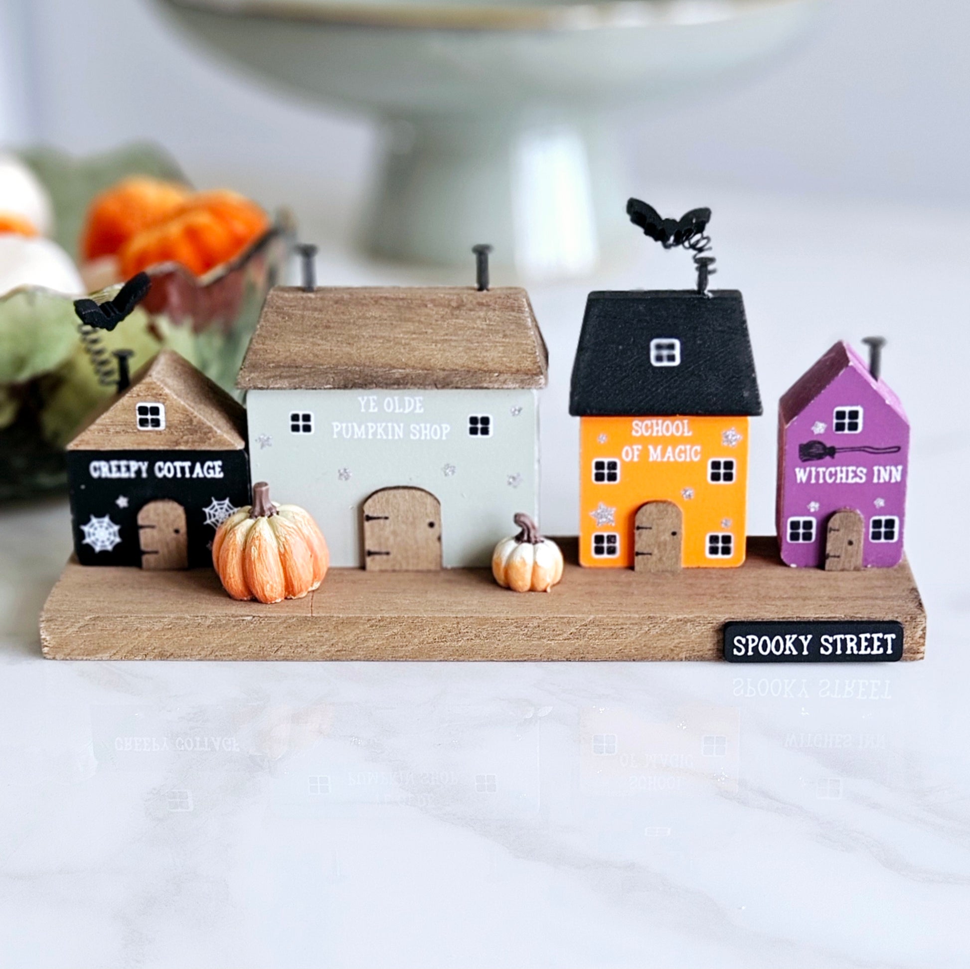 spooky street houses block with bats on roof and pumpkins out front