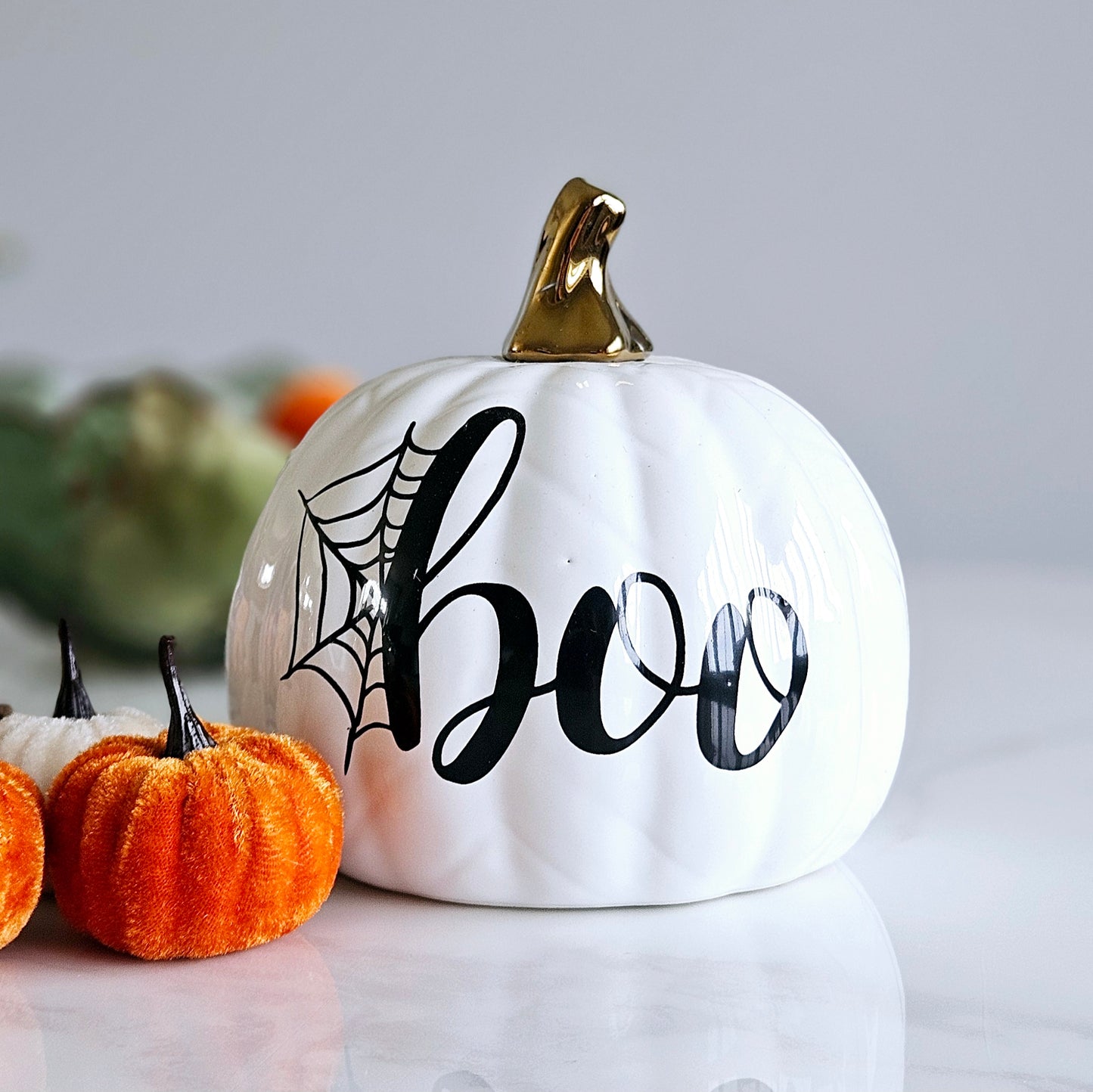 white pumpkin with word BOO on front and cobbled design with a gold stalk