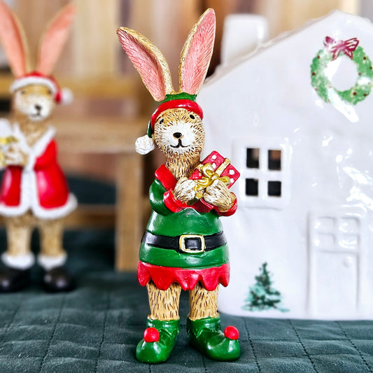 bunny ornament dresses in a green and red elf costume holding a present