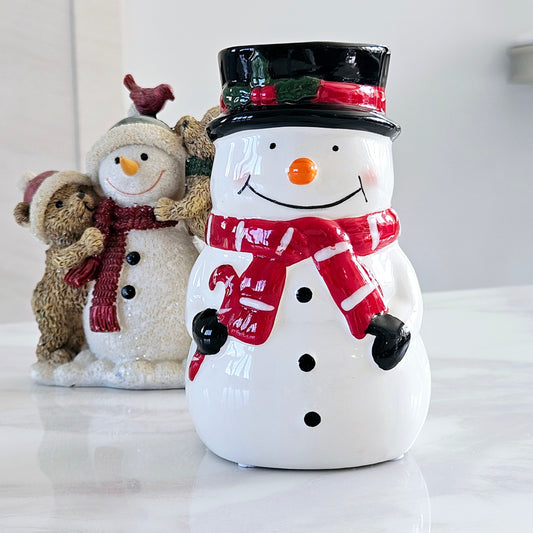 ceramic snowman wax melt burner with black hat and red and white scarf holding a candy cane