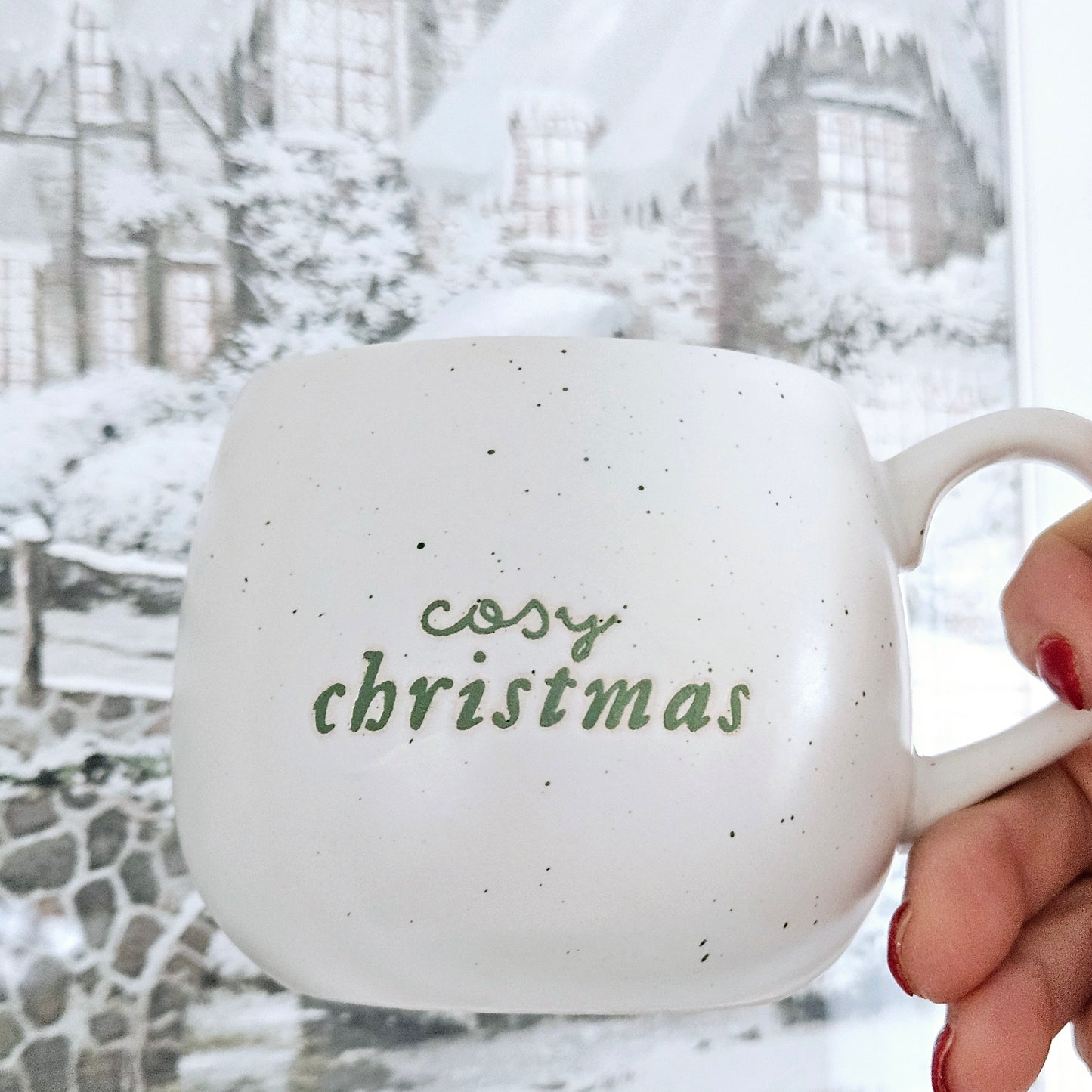 white cosy christmas mug with green font and green speckled finish