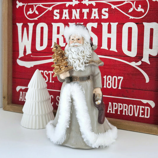 Santa Claus Ornament dressed in grey with faux white fur trim holding a gold Christmas tree