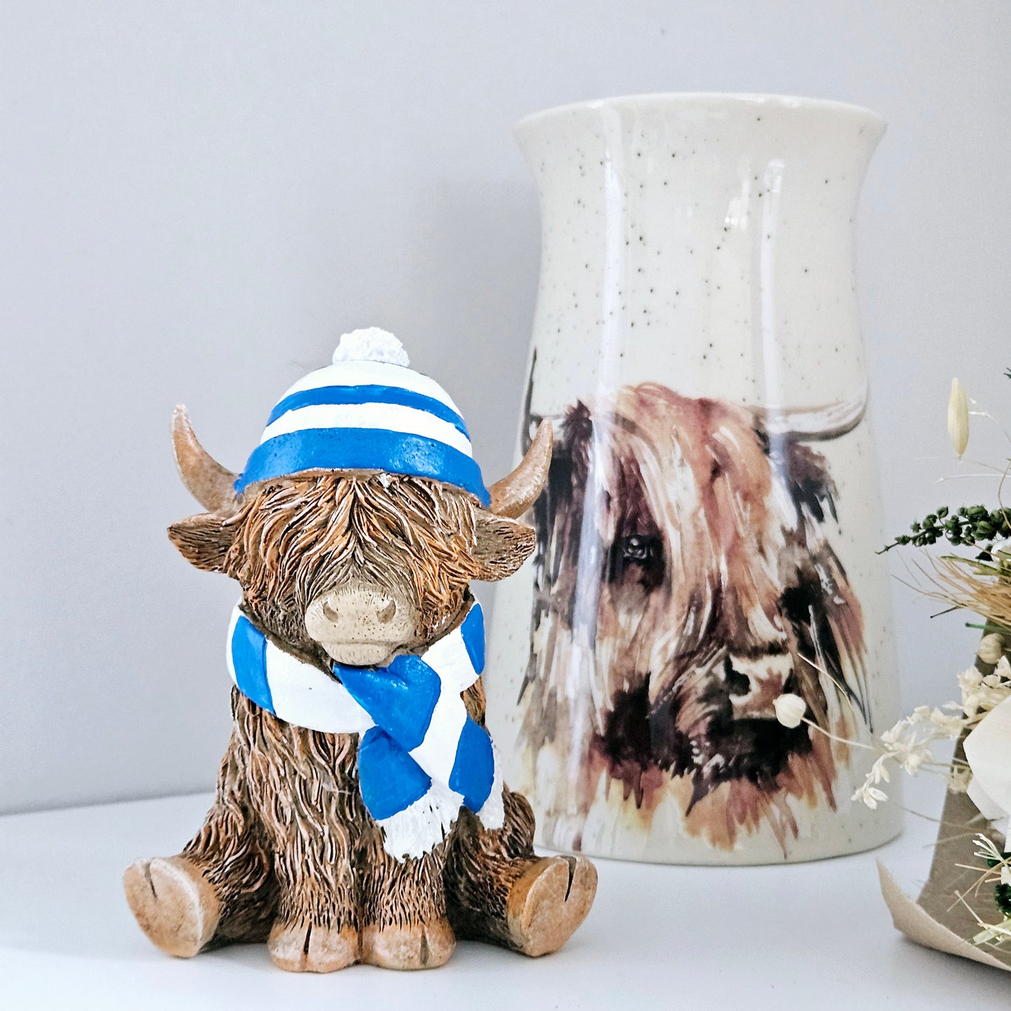 Highland cow Ornament wearing a blue and white stripped hat and scarf 