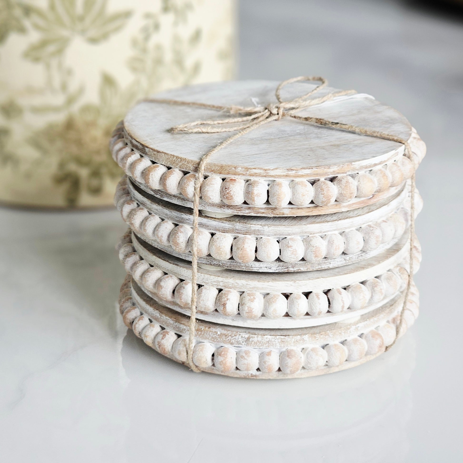 Stack of 4mango wood beaded coasters tied with twine
