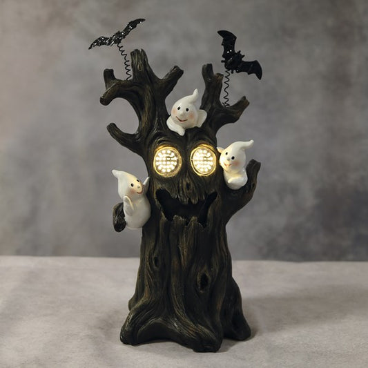 A Halloween-themed decorative tree stump figurine with glowing round eyes, three small white ghost figures, and two black bats perched on the branches. lED ghost scary tree Halloween decoration