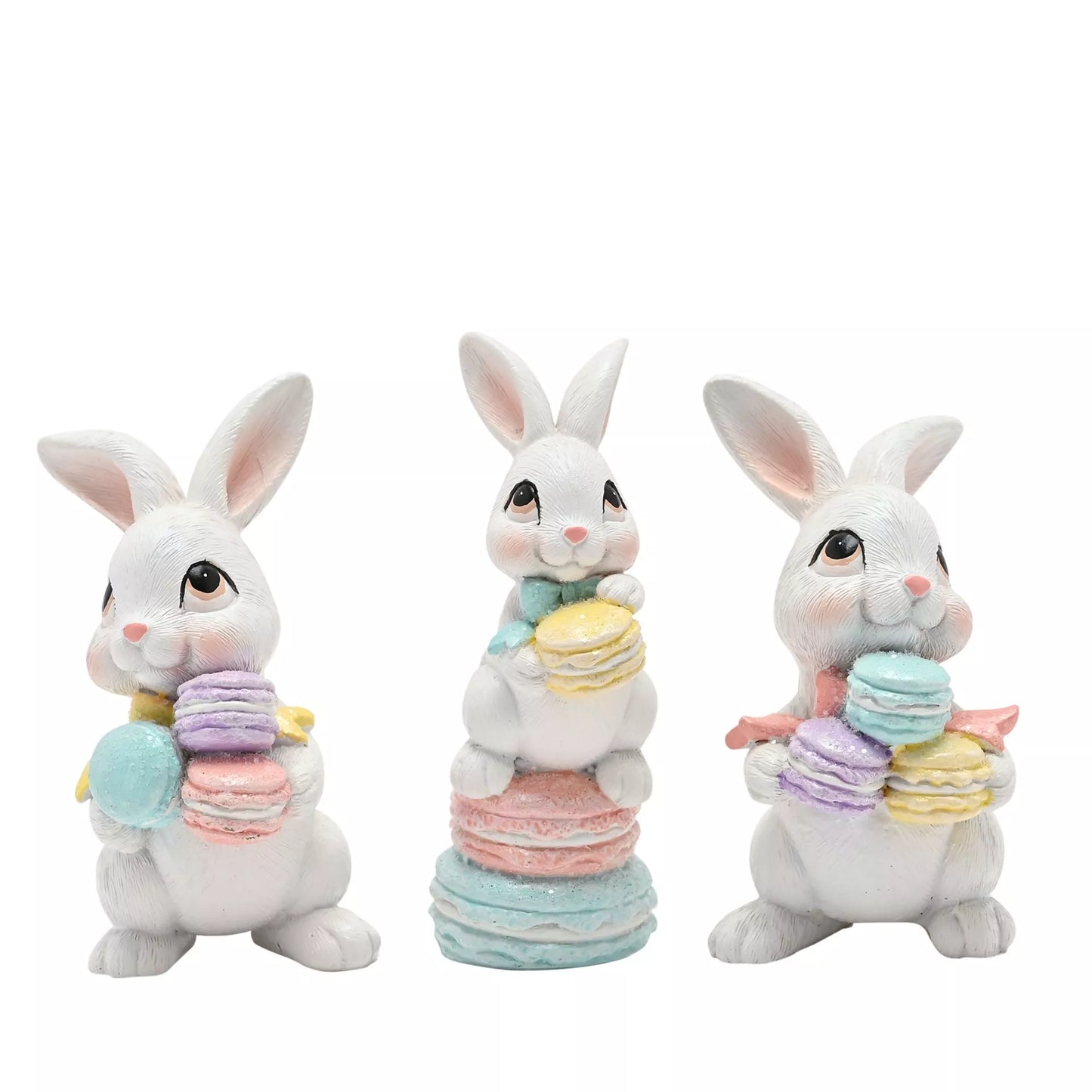 Three decorative bunny figurines holding colorful macaron stacks 