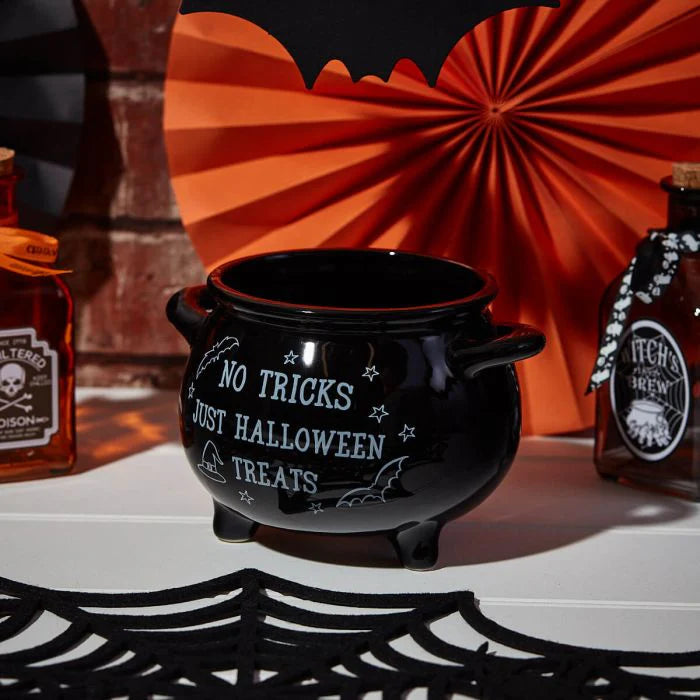 Black ceramic Halloween treat holder cauldron with white quote filled with sweets for seasonal home décor.