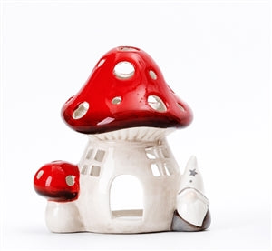 ceramic mushroom or toadstool tea light holder in red and white with a gonk attached to it 