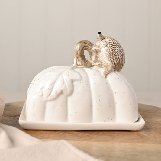 hedgehog butter dish with leaf and brown speckles on a white ceramic