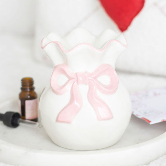 white ceramic wax water with pink bow and hear tea light back