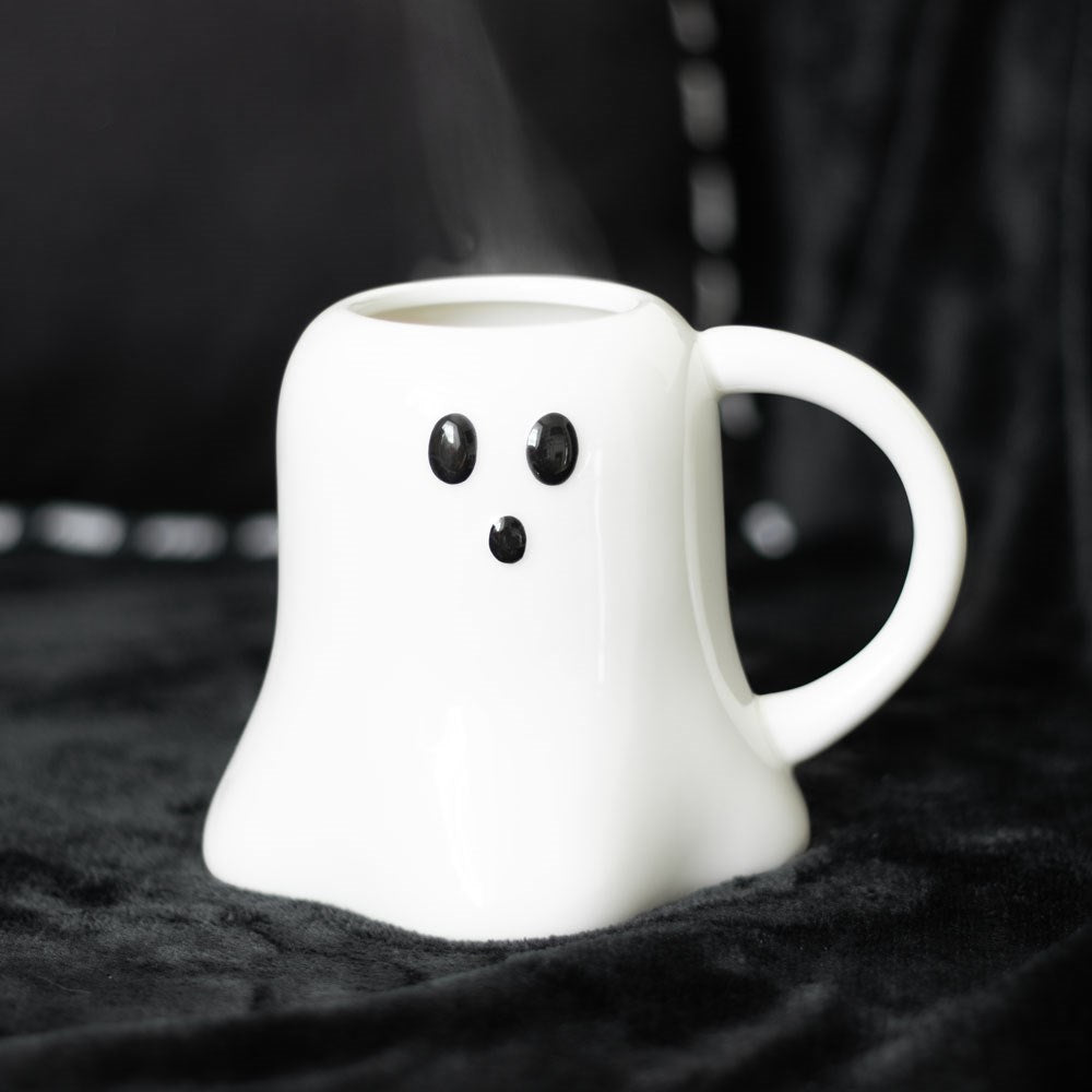 white ghost shaped mug with black eyes and nose