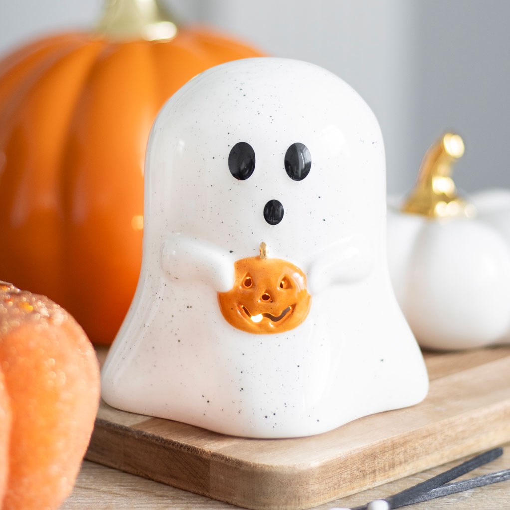 ghost tea light holder holding a orange pumpkin