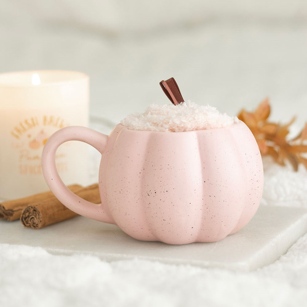 Pink pumpkin-shaped mug pink fluffy socks inside