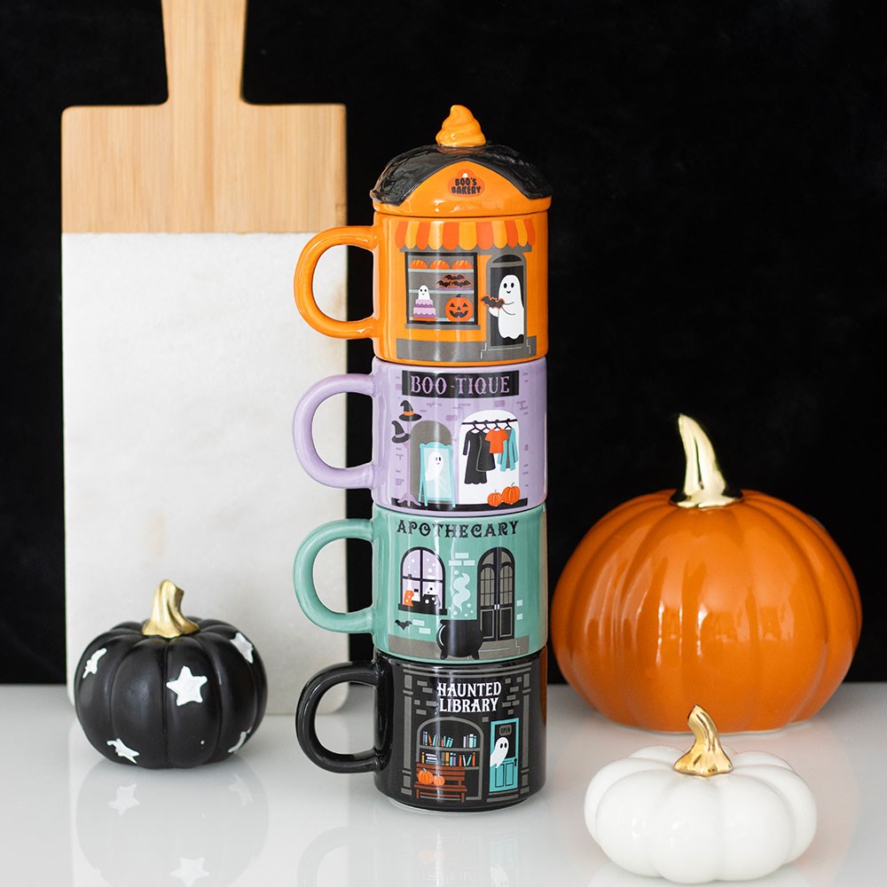 Stack of Halloween-themed mugs with pumpkins and ghosts