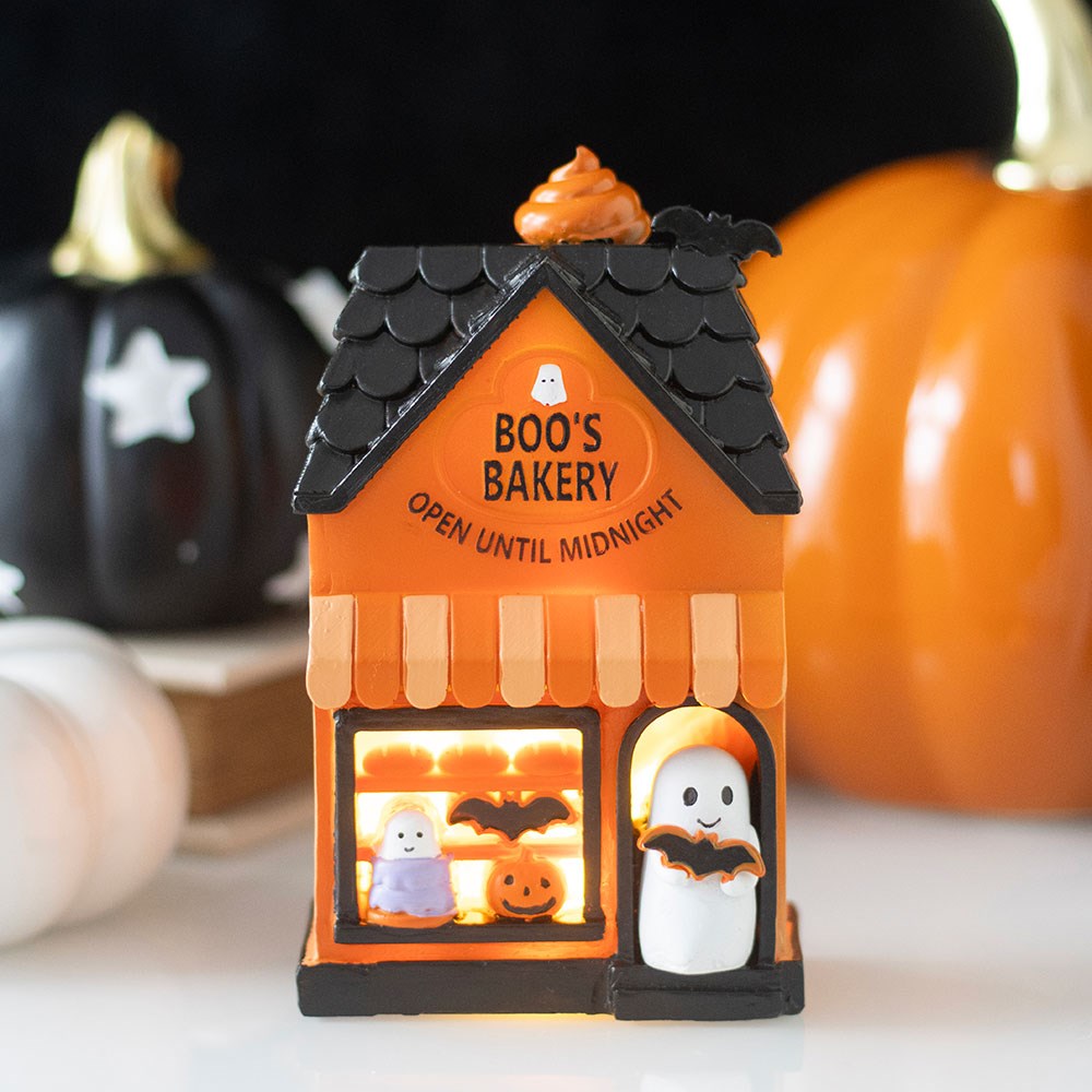 Halloween-themed decorative light-up house with 'Boo's Bakery' text, ghosts, and pumpkins 