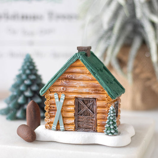 Miniature log cabin ski chalet with green roof, skis, and small trees incense holder 