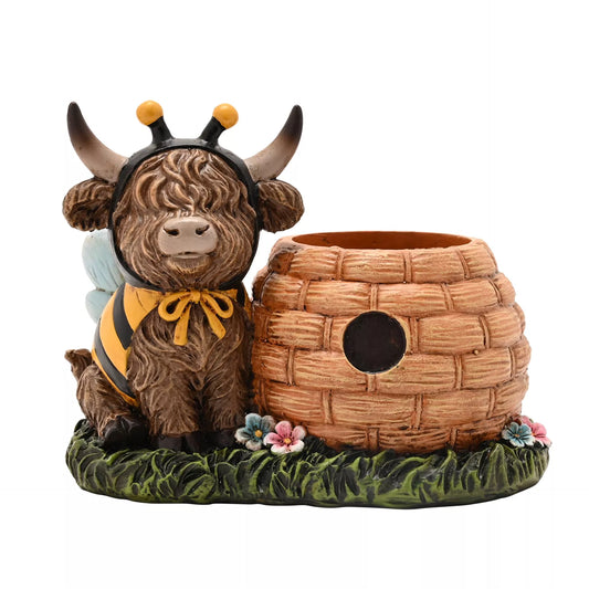 Decorative figurine of a highland cow in a bee costume with a beehive as a planter