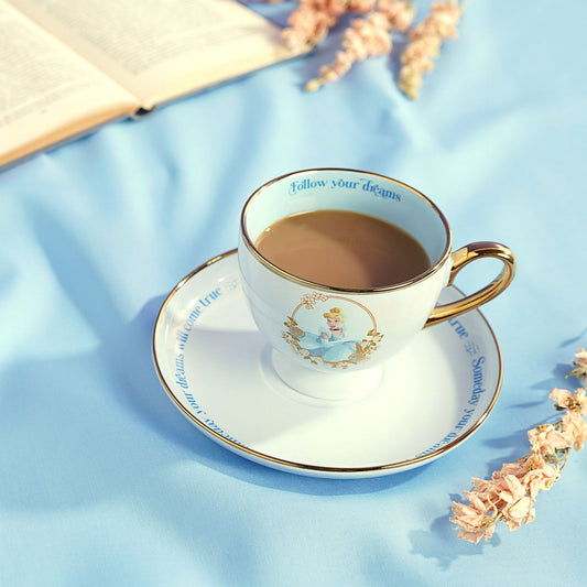 cinderella tea cup and saucer set in blue with follow your dreams text and gold rim and handle