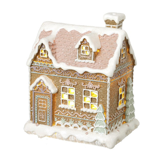Decorative Christmas house with snow and lights in pink and pastel colours