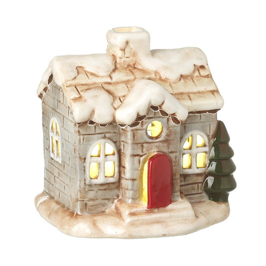Decorative ceramic christmas light up cottage house with snow on the roof, lit interior, and red door.